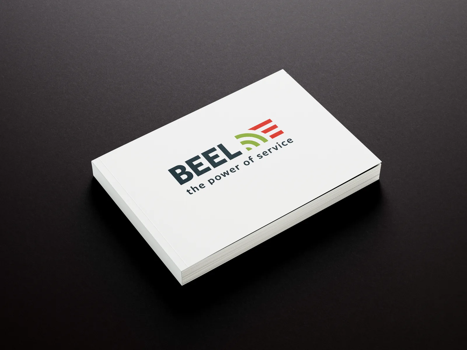Het BEEL-brandbook, gesloten op een zwarte ondergrond: het logo en de baseline 'the power of service' op de cover.